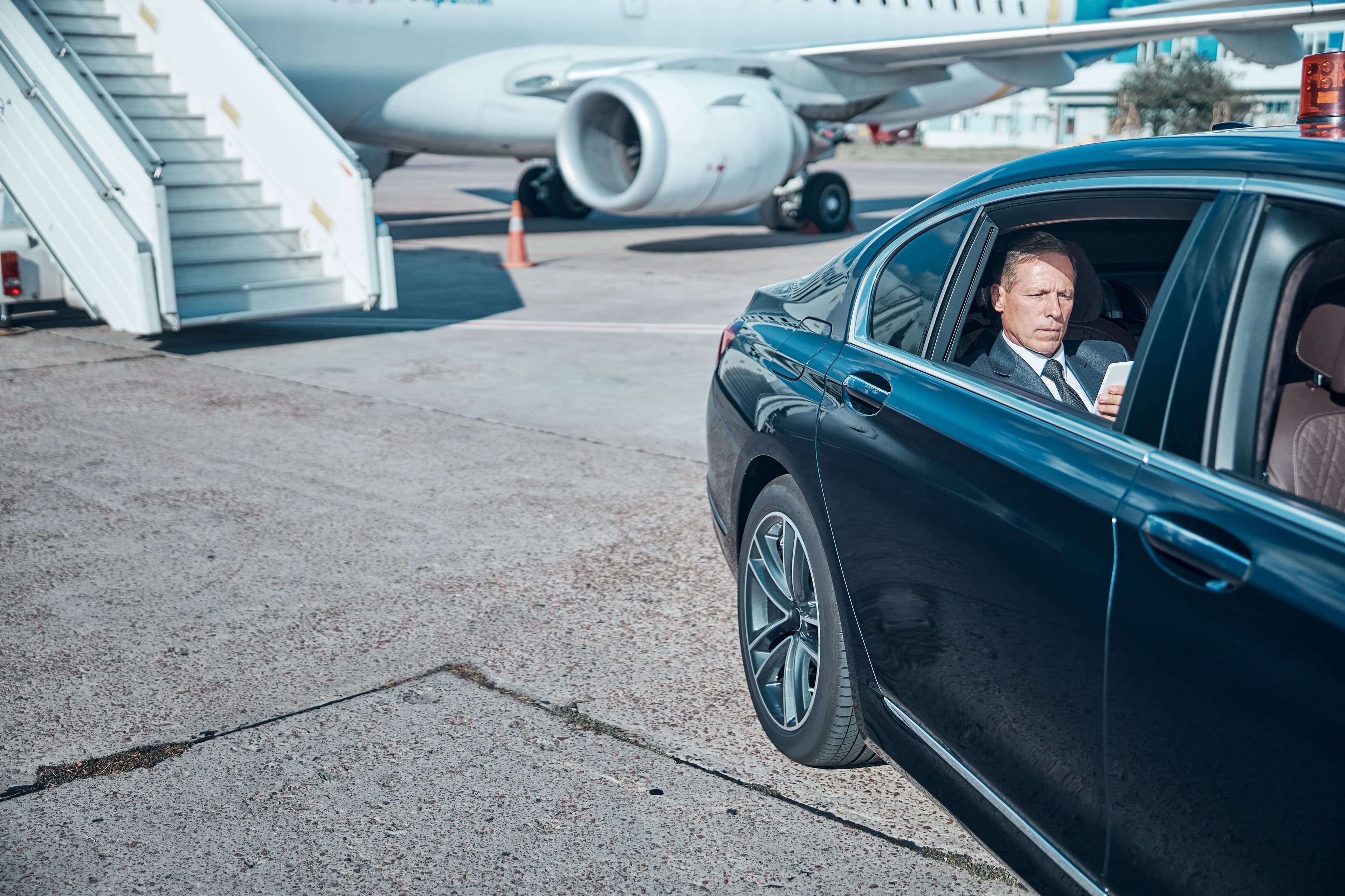Chauffeured black car waiting on the airport tarmac